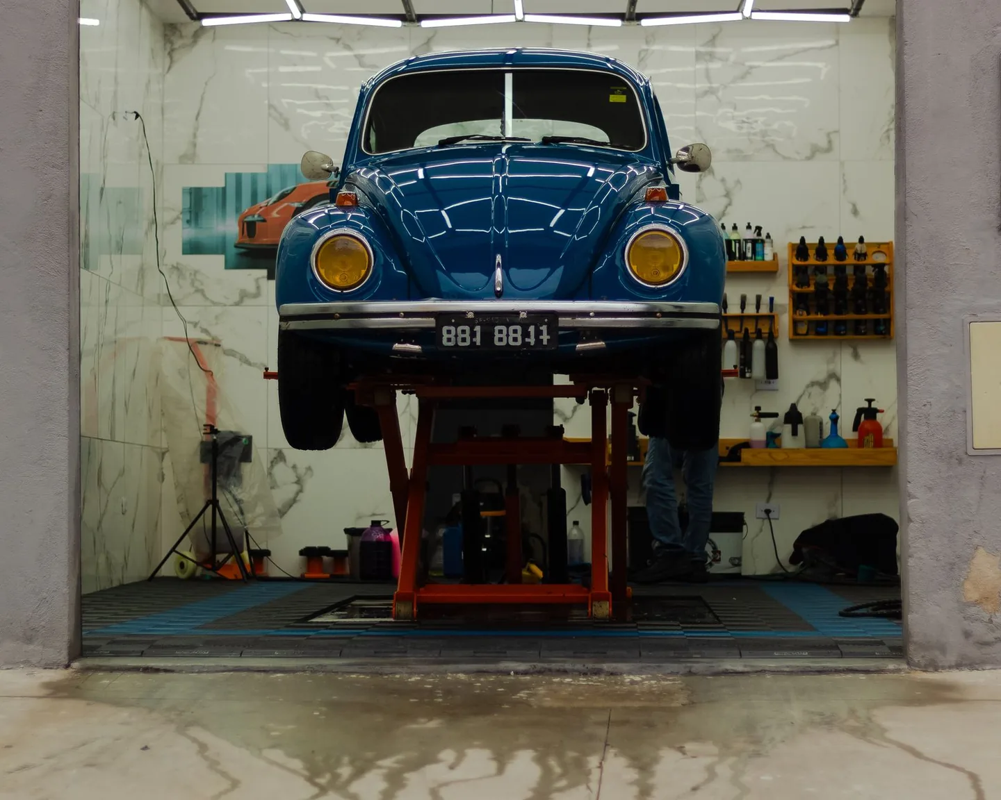 A car raised on a hoist inside a vehicle customisation workshop